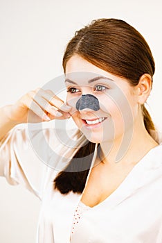 Woman applying pore strips on nose