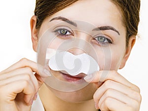 Woman applying pore strips on nose