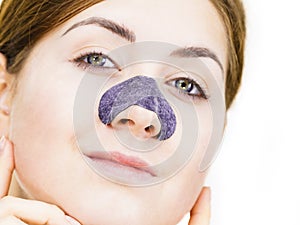 Woman applying pore strips on nose