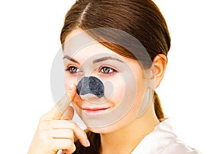 Woman applying pore strips on nose