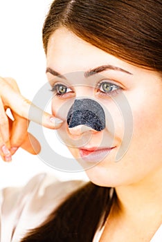 Woman applying pore strips on nose