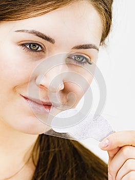 Woman applying pore strips on nose