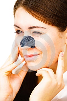 Woman applying pore strips on nose