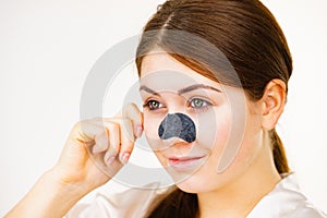 Woman applying pore strips on nose