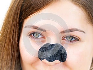 Woman applying pore strips on nose