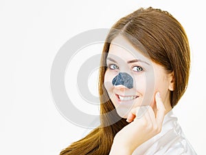 Woman applying pore strips on nose