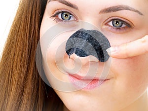 Woman applying pore strips on nose