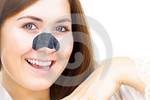 Woman applying pore strips on nose