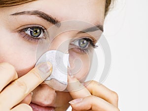 Woman applying pore strips on nose