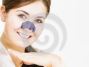 Woman applying pore strips on nose