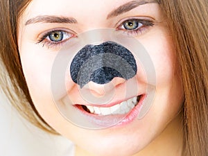 Woman applying pore strips on nose