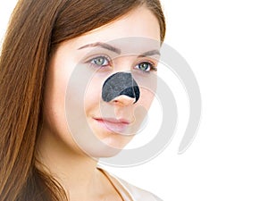 Woman applying pore strips on nose