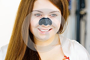 Woman applying pore strips on nose