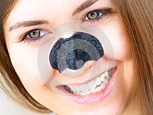 Woman applying pore strips on nose