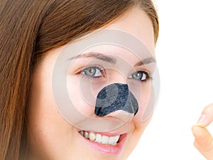 Woman applying pore strips on nose