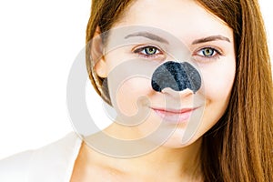 Woman applying pore strips on nose