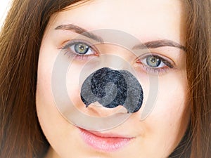 Woman applying pore strips on nose