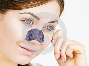 Woman applying pore strips on nose