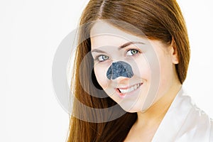 Woman applying pore strips on nose