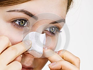 Woman applying pore strips on nose