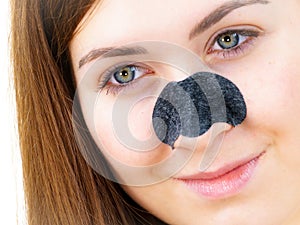 Woman applying pore strips on nose