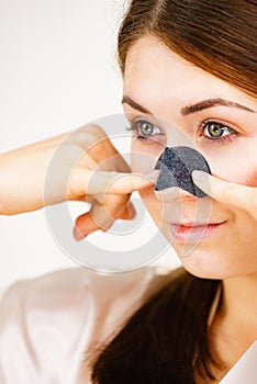 Woman applying pore strips on nose