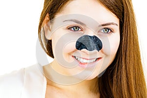 Woman applying pore strips on nose