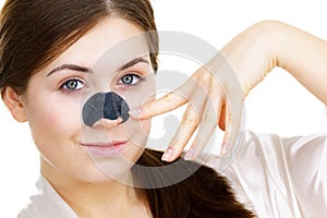 Woman applying pore strips on nose