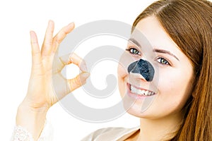 Woman applying pore strips on nose