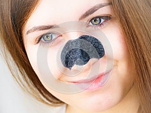 Woman applying pore strips on nose