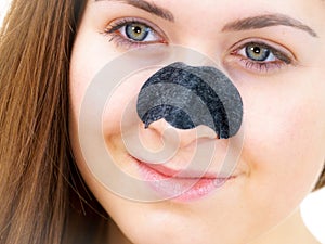 Woman applying pore strips on nose