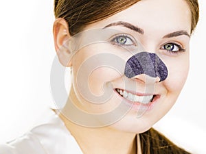 Woman applying pore strips on nose