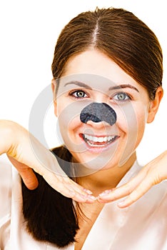 Woman applying pore strips on nose photo