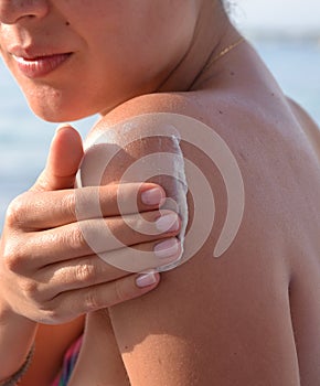 Woman applying protection sun body cream