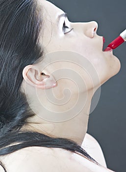 Woman applying red lipstick