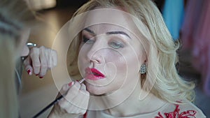 Woman applying red lipstick. Beautiful model -make up-lips. Make up.