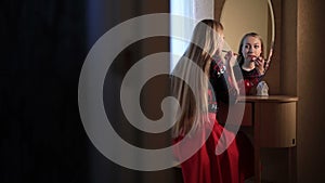 woman applying red lipstick on Christmas Eve