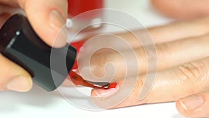 Woman applying red nail polish