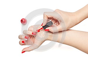 Woman applying red nail polish her nails manicure on white background isolated