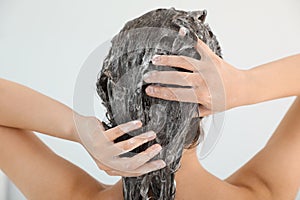 Woman applying shampoo onto her hair