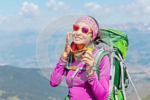 Woman applying sun cream to protect her skin from dangerous uv sun rays high in mountains. Travel healthcare concept