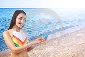 Woman applying sun protection cream at beach, space for text