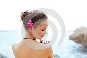 Una mujer el uso crema sobre el bronceado hombro. protección de la piel. cuerpo el sol proteccion el sol crema. una mujer mancha hidratante 