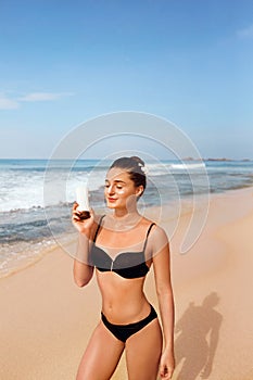 Woman applying sunscreen creme on tanned shoulder. Skincare. Body Sun protection suncream.