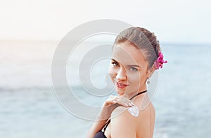 Woman Applying Sunscreen Creme on  Tanned  Shoulder. Skincare. Sun Protection. Girl Using Sun cream Lotion