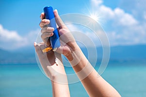 A woman is applying sunscreen and skin care to protect her skin from UV rays. She is applying sunscreen on her hand and arm. The