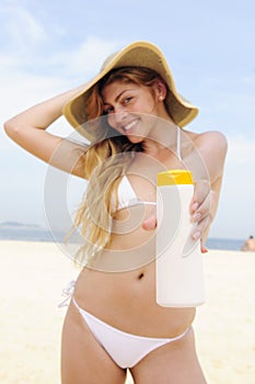 Woman applying suntan lotion at the beach