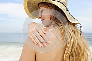 Woman applying suntan lotion at the beach