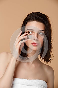 Woman applying under eye moisturising patches photo