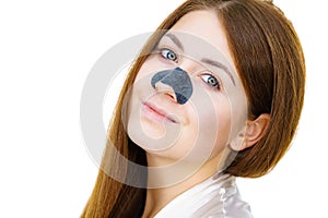Woman applying pore strips on nose photo
